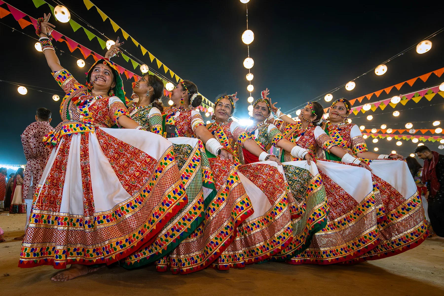 Garba dancers celebrating beneath colourful lights