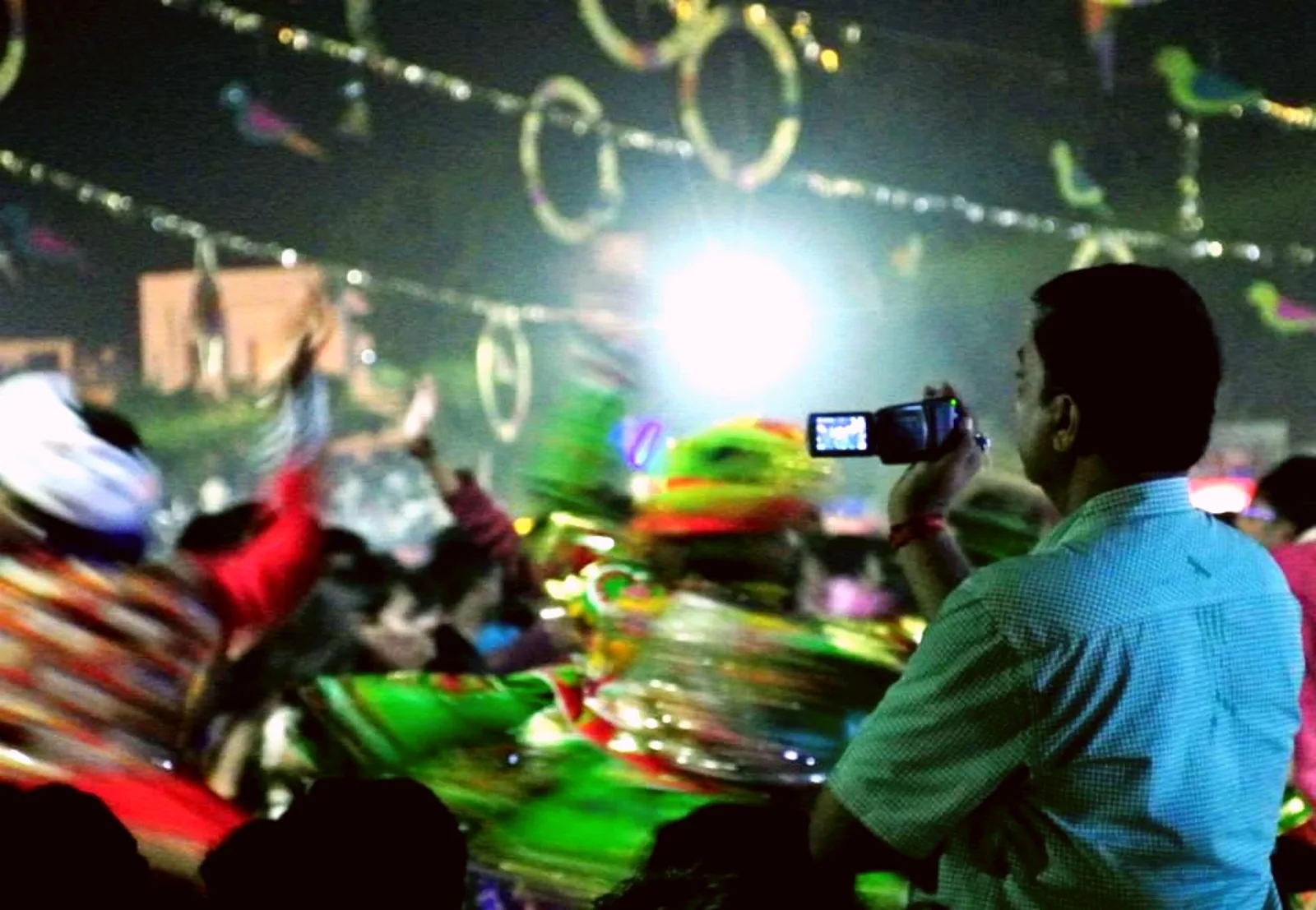 Garba performers moving beneath festive night lights